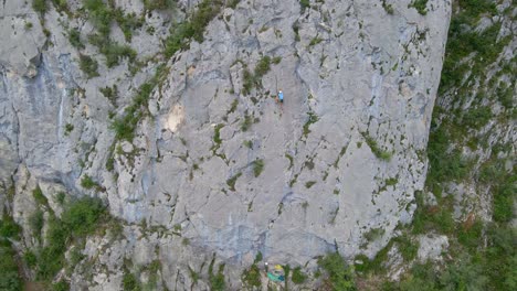 Distant-drone-footage-of-a-man-top-rope-climbing-in-the-Pyrenees-moutains-at-Tarascon-sur-Ariège