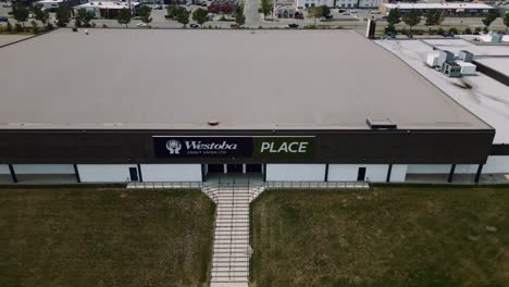 A-4K-Reveal-Backwards-Aerial-Cinematic-Drone-Shot-of-Busy-City-18th-Street-Downtown-Westoba-Place-Keystone-Center-Stadium-Wheat-Kings-Hockey-Arena-in-Prairies-Town-Brandon-Manitoba-Canada