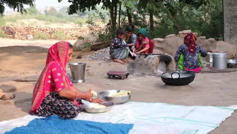A-village-scene-with-a-woman-cooking-in-the-kitchen-and-small-children-reading-a-book