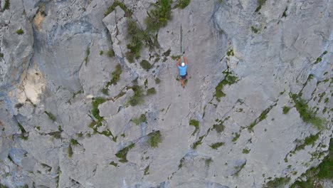 Top-down-drone-footage-of-a-man-top-rope-climbing-in-the-Pyrenees-moutains-at-Tarascon-sur-Ariège