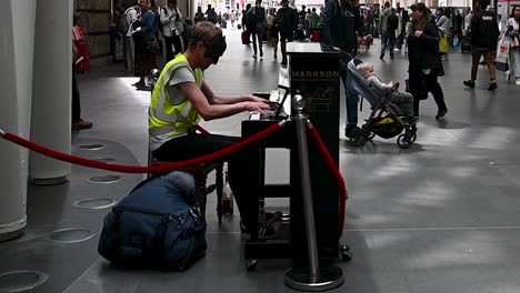Playing-the-Piano-within-Kings-Cross-Station,-London,-United-Kingdom