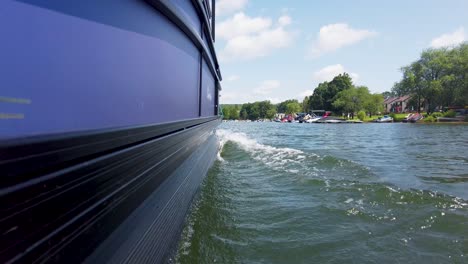 low-waterline-shot-of-pontoon-boat-slowly-cutting-through-the-water