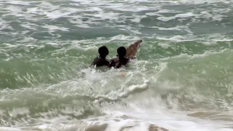 Two-nigerian-kids-surfing-witha-makeshift-board