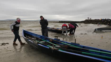 Currach-boats-are-prepared-and-oars-carried-into-boats-at-ladies-beach