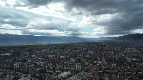 View-of-roofed-houses-and-streets-in-the-city-of-Tetovo,-drone-view-of-a-cloudy-sky,-a-city-in-the-Balkans