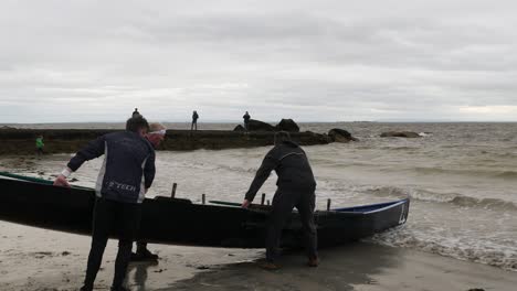 Currach-paddling-racing-team-carries-lifting-boat-into-open-atlantic-ocean