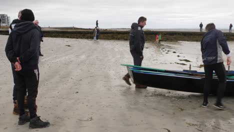 Team-of-currach-boat-racers-gather-around-traditional-boat-discussing-compettion