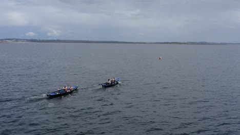 Rear-side-view-of-currach-rowers-paddling-towards-buoy-in-open-ocean