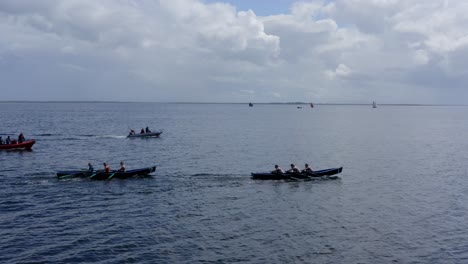 Low-angle-side-to-side-tracking-view-of-currach-boats-and-support-crew-in-inflatable-motorboat