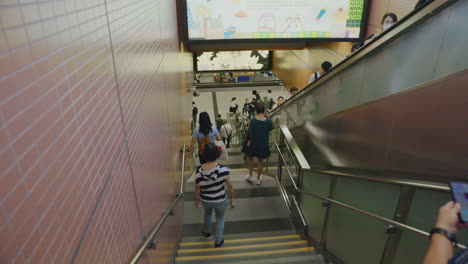 Camera-moving-down-the-stairs-toward-the-metro-station-of-an-extremely-busy-stop-in-Hong-Kong