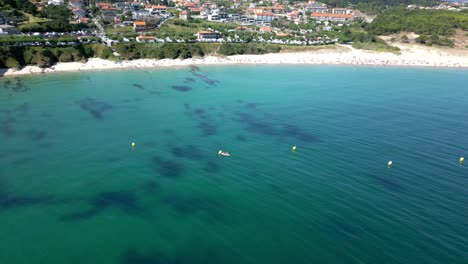Peaceful-Jade-Sea-with-Clear-Water-in-Beachfront-Hotel-and-Houses-Aerial-Footage
