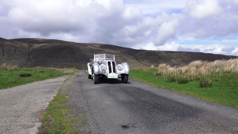 Historic-rally-car-on-The-Comeragh-Mountains-Waterford-Ireland-at-speed-on-a-remote-mountain-radon-a-warm-summer-day