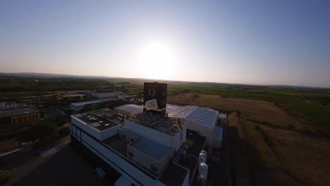 Aerial-FPV-diving-shot-overhead-the-Carte-Noire-factory-and-vineyards-in-Montpellier