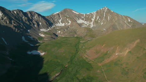 Aerial-cinematic-drone-early-morning-sunrise-hiking-trail-Grays-and-Torreys-14er-Peaks-Rocky-Mountains-Colorado-stunning-landscape-view-mid-summer-green-beautiful-snow-on-top-forward-up-high-movement