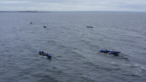 Drone-descends-over-Currach-boats-racing-across-rocky-ocean