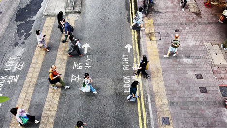 Vista-De-Arriba-Hacia-Abajo-De-Una-Multitud-Enmascarada-Cruzando-Una-Calle-En-Hong-Kong-Durante-La-Pandemia-De-Covid-19