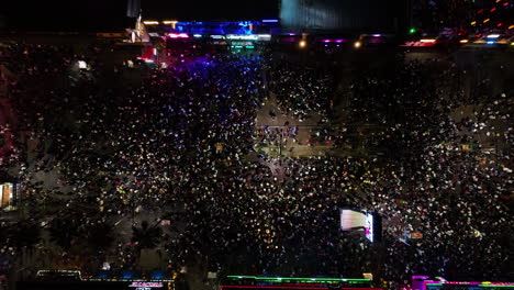 Aerial-view-above-people-at-the-San-Marcos-fair,-night-in-Aguascalientes,-Mexico---top-down,-drone-shot