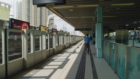 Dynamische-Aufnahme-Von-Menschen,-Die-Auf-Dem-Bahnsteig-In-Hongkong,-Asien,-Auf-Ihren-Zug-Warten
