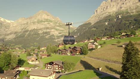 dolly-sideways-left-to-right-following-an-ascending-cabin-of-tricable-car-system-Eiger-Express-in-Grindelwald-in-fantastic-evening-light-with-clear-sky