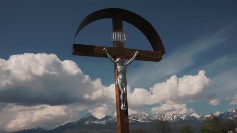 Cross-with-Jesus-in-front-of-mountains-with-clouds