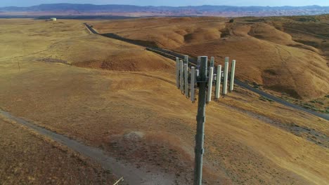 4k-drone-footage-orbiting-around-a-cellular-tower-with-golden-hills-and-blue-skies