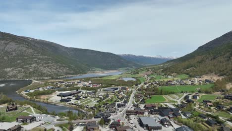 Lom-and-Fossbergom-with-Bovra-river-mouth-in-Norway---High-angle-backward-moving-aerial