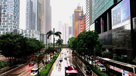 Slow-Motion-Traffic-on-Rain-Soaked-Gloucester-Road,-Hong-Kong-on-a-Gloomy-Day