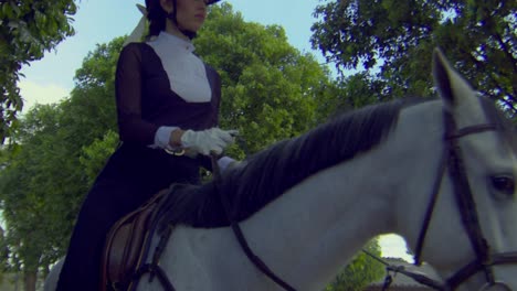 Horsewoman-walking-with-her-beautiful-white-horse,-slow-motion-low-angle