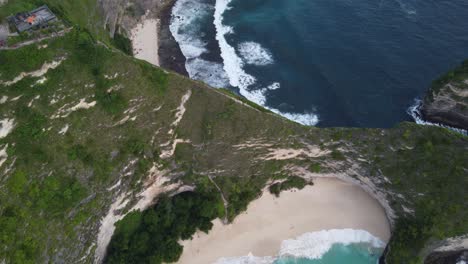 Panoramic-Aerial-view-of-Kelingking-Beach-Viewpoint-and-hiking-trail-on-the-edge-of-a-steep-cliff-down-to-white-sand-Cove,-Nusa-Penida-Island