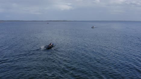 Drone-dolly-follows-rowers-in-currach-irish-boats-into-open-ocean