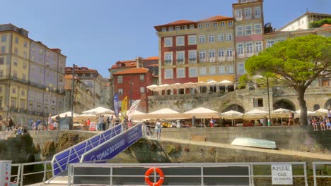 Tourists-Wandering-Along-The-Colorful-Buildings-In-Ribeira-District-Through-Promenade-In-Porto,-Portugal