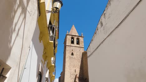 View-Tower-of-Santiago-el-Mayor-church-from-a-street-alley,-Cáceres,-Spain