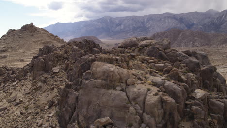 Close-Up-Drone-Aerial-above-the-Alabama-Hills-of-California,-Sierra-Nevada-Mountain-Range-in-the-background
