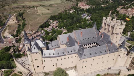 Aerial:-Alcázar-de-Segovia-with-Spain-Flag-flying-proudly-amidst-Scenic-landscape