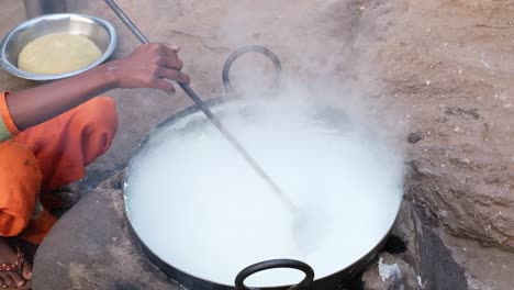 The-process-of-heating-the-milk-by-pouring-it-into-the-pan-placed-on-the-stove-is-going-on