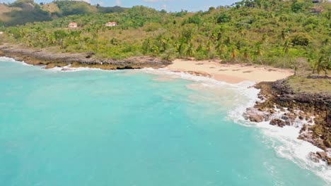 Aerial-view-showing-private-Playa-del-Amor-Beach-with-clear-water-and-tropical-landscape-in-sun---Las-Galeras,-Samana,-Dominican-Republic