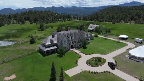 Aerial-view-of-beautiful-mansion-located-in-mountains-surrounded-by-woodland