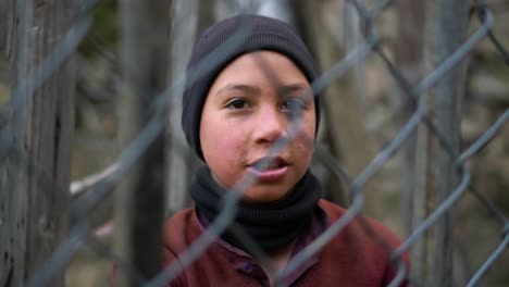 A-young-teenage-Kashmiri-boy-stands-behind-the-fence---Imprisonment,-confinement,-restriction-idea
