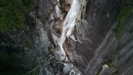 Aerial-pan-up-of-Shannon-Falls-bottom-waterfall,-Squamish,-BC,-Canada