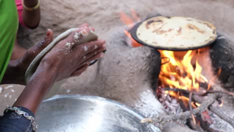 close-up-scene-of-a-village-woman-making-millet-bread-in-a-stove-and-making-millet-bread-by-tapping-millet-flour-with-both-hands