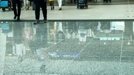 Many-travelers-are-seen-on-a-reflective-floor-in-the-passenger-terminal-of-the-airport