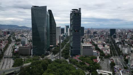 Aerial-hyperlapse-of-the-towers-of-Paseo-de-la-Reforma-and-surroundings-of-Chapultepec,-a-park-in-Mexico-City,-right-pan