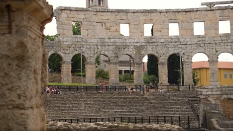 People-sitting-on-steps-inside-Amphitheater,-Pula,-Northwestern-Croatia