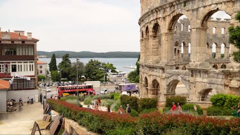 Locals-and-tourists-arrive-by-bus-and-motorcar-to-the-Amphitheater,-Pula