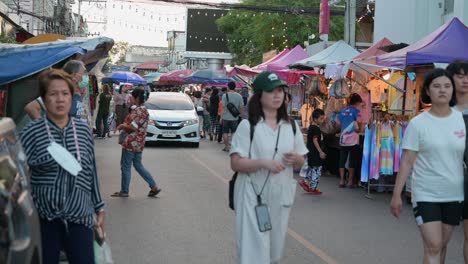 Touristen-Und-Familien-Gehen-Auf-Dem-Nachtmarkt-Spazieren-Und-Kaufen-Lebensmittel,-Bevor-Sie-Eine-Bootsfahrt-Auf-Dem-Schwimmenden-Markt-Von-Amphawa-In-Thailand-Unternehmen
