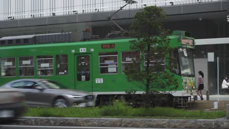 Green-Streetcar-And-Cars-Travelling-In-The-Sapporo-City,-Japan