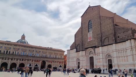 Piazza-Maggiore-city-square-with-Basilica-di-San-Petronio-in-Bologna,-Italy-with-a-lot-of-tourists-visiting-the-landmark