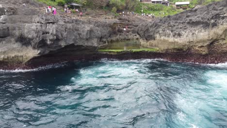Tourists-flocking-to-Angel's-Billabong,-a-natural-tidal-rock-pool-formation-and-photo-spot-on-Nusa-Penida-Island,-Bali