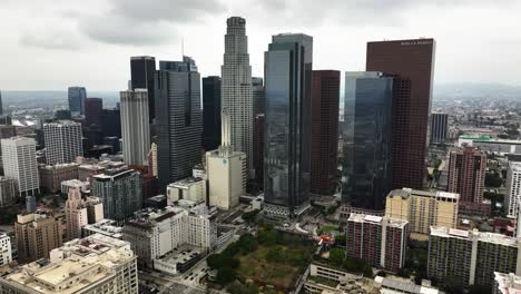 Drone-shot-orbiting-the-skyline-of-Los-Angeles-city,-overcast-day-in-CA,-USA