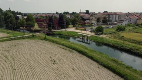 Landwirtschaftliches-Feld-Gepflügtes-Land-Mit-Bewässerungskanalfluss-In-Cassolnovo,-Italien,-Luftaufnahme